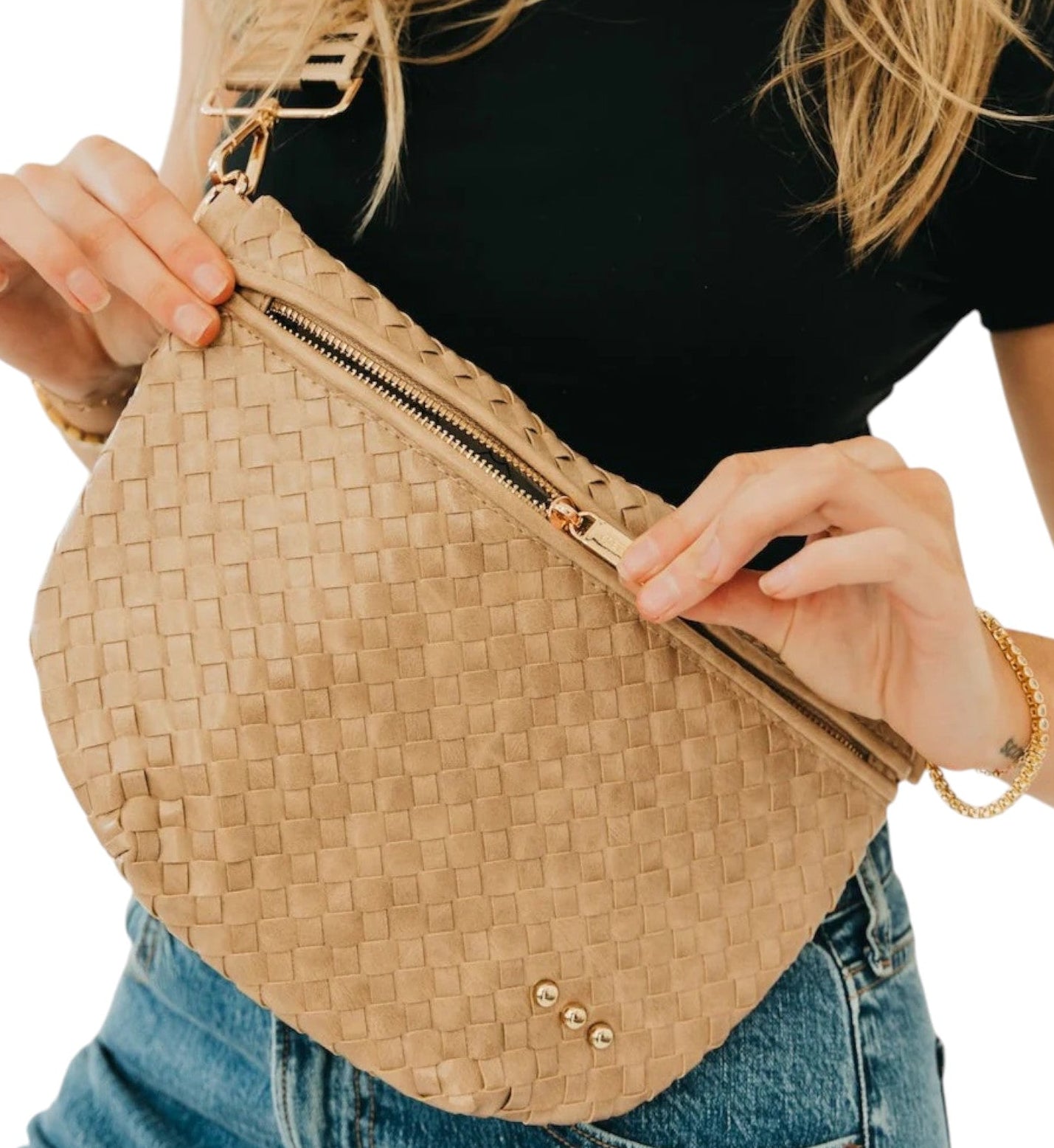Person holding a woven beige bag with a plain background.