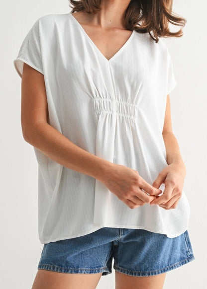 White V-neck tunic with smocking and subtle stripe texture.