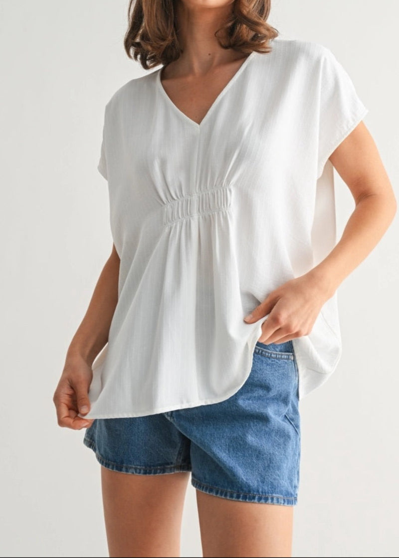 White V-neck tunic with smocking and subtle stripe texture.