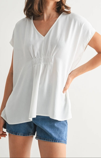 White V-neck tunic with smocking and subtle stripe texture.