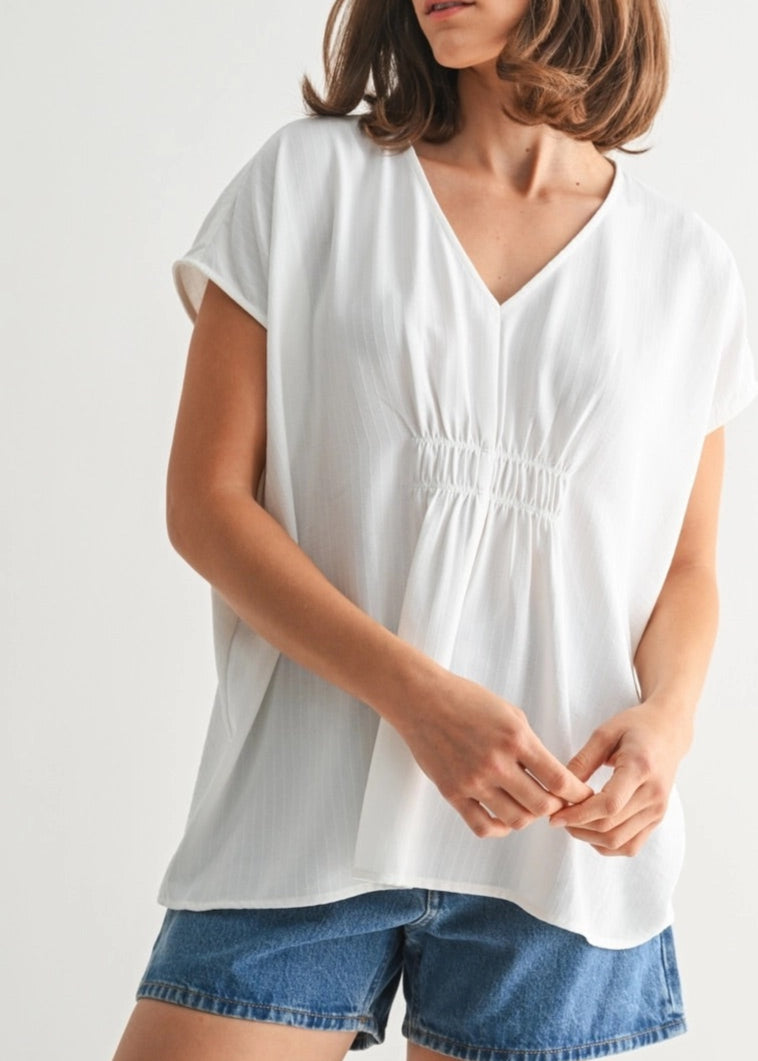 White V-neck tunic with smocking and subtle stripe texture.