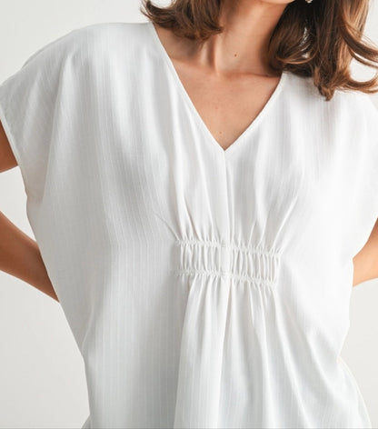 White V-neck tunic with smocking and subtle stripe texture.