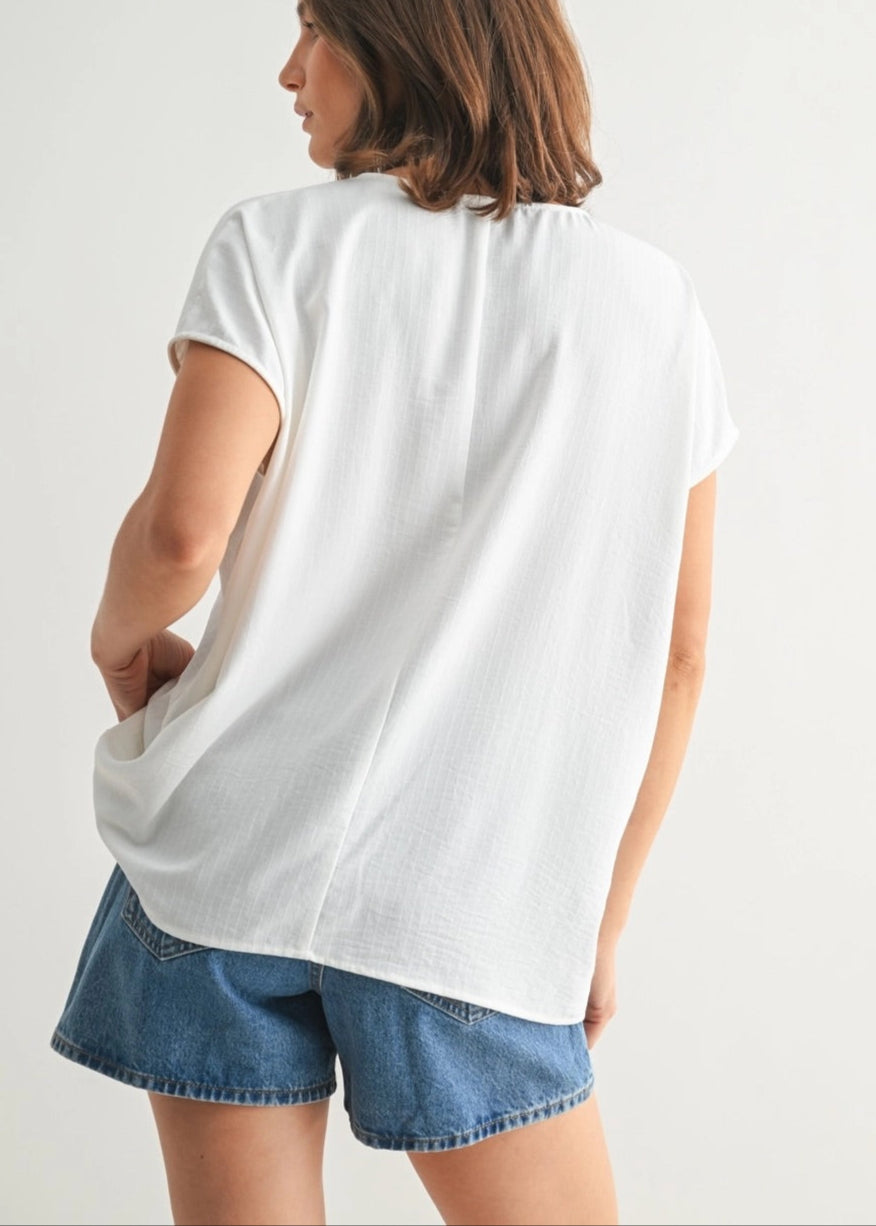 White V-neck tunic with smocking and subtle stripe texture.