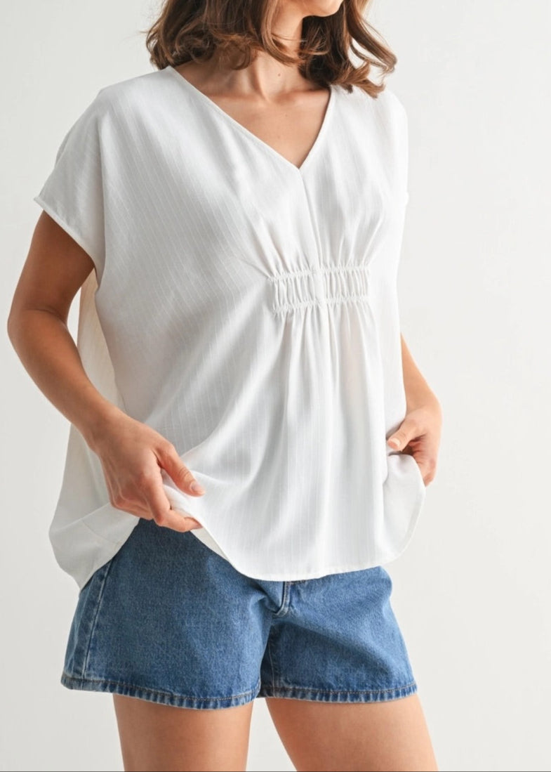 White V-neck tunic with smocking and subtle stripe texture.