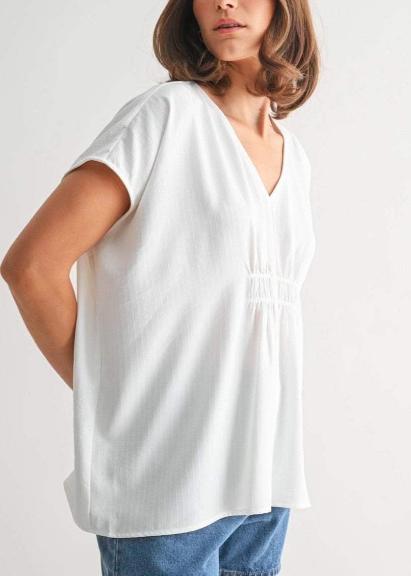 White V-neck tunic with smocking and subtle stripe texture.