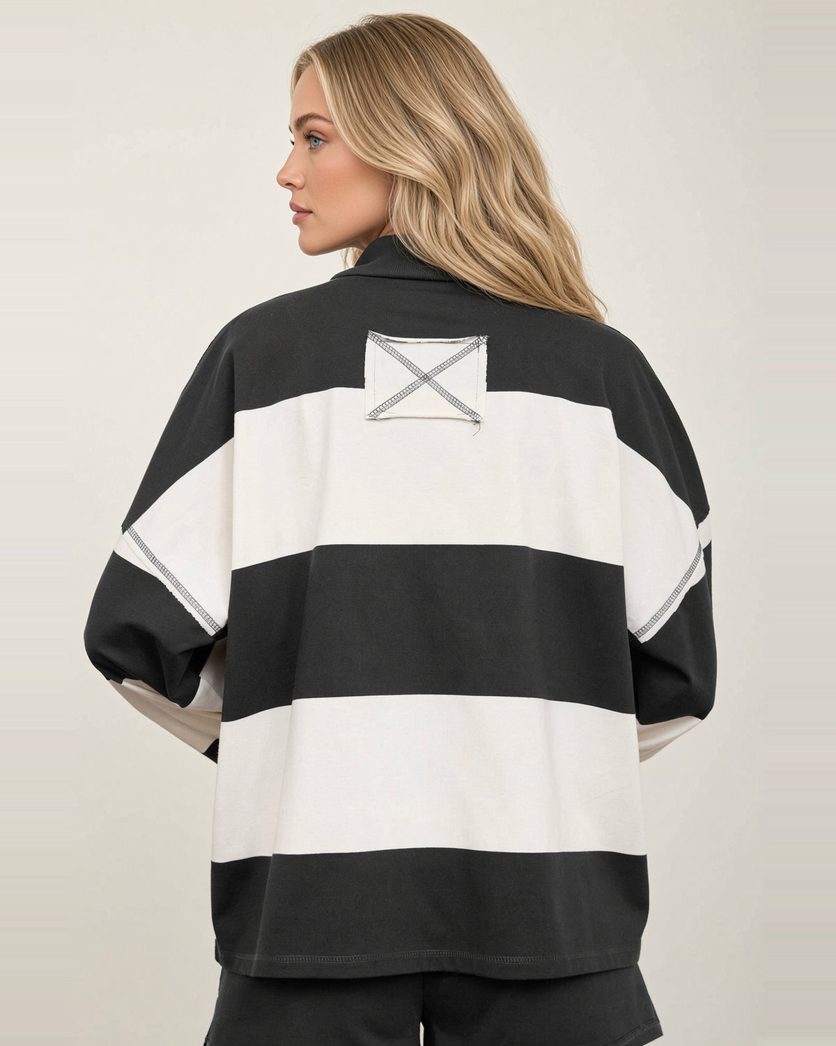 Back view of the Rally Stripe top with wide charcoal and ivory stripes and a contrast X-stitched upper-back patch.